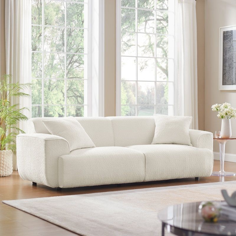 “MINIMORE Modern Style Sofa 91-inch Round Arm Sofa by Latitude Run, available on Wayfair. This stylish sofa features a soft, stretch boucle fabric cover in multiple colors, mid-firm seating, and a modern design with round arms. Ideal for contemporary living rooms, it includes two toss pillows and offers a comfortable seating experience with a deep seat and low profile. Professional furniture assembly services available to ensure a quick and hassle-free setup, enhancing your home’s comfort and style.”