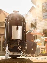 "Weber Smokey Mountain Cooker Smoker 14" in action, smoking delicious Ribs and Brisket Outdoors, Perfect for The Backyard BBQ's and Gatherings."